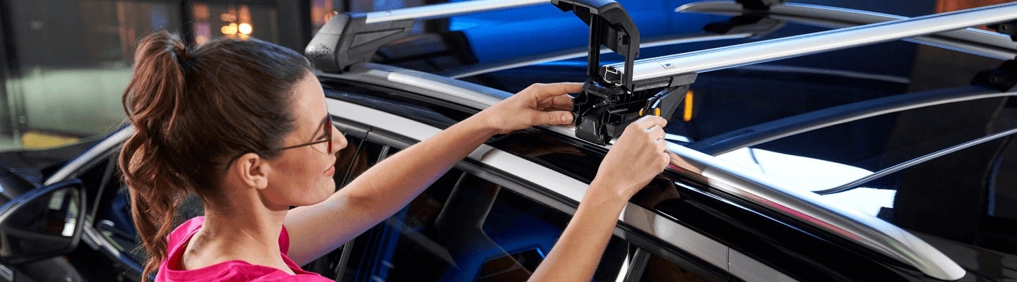 image of a woman putting a rack on a car
